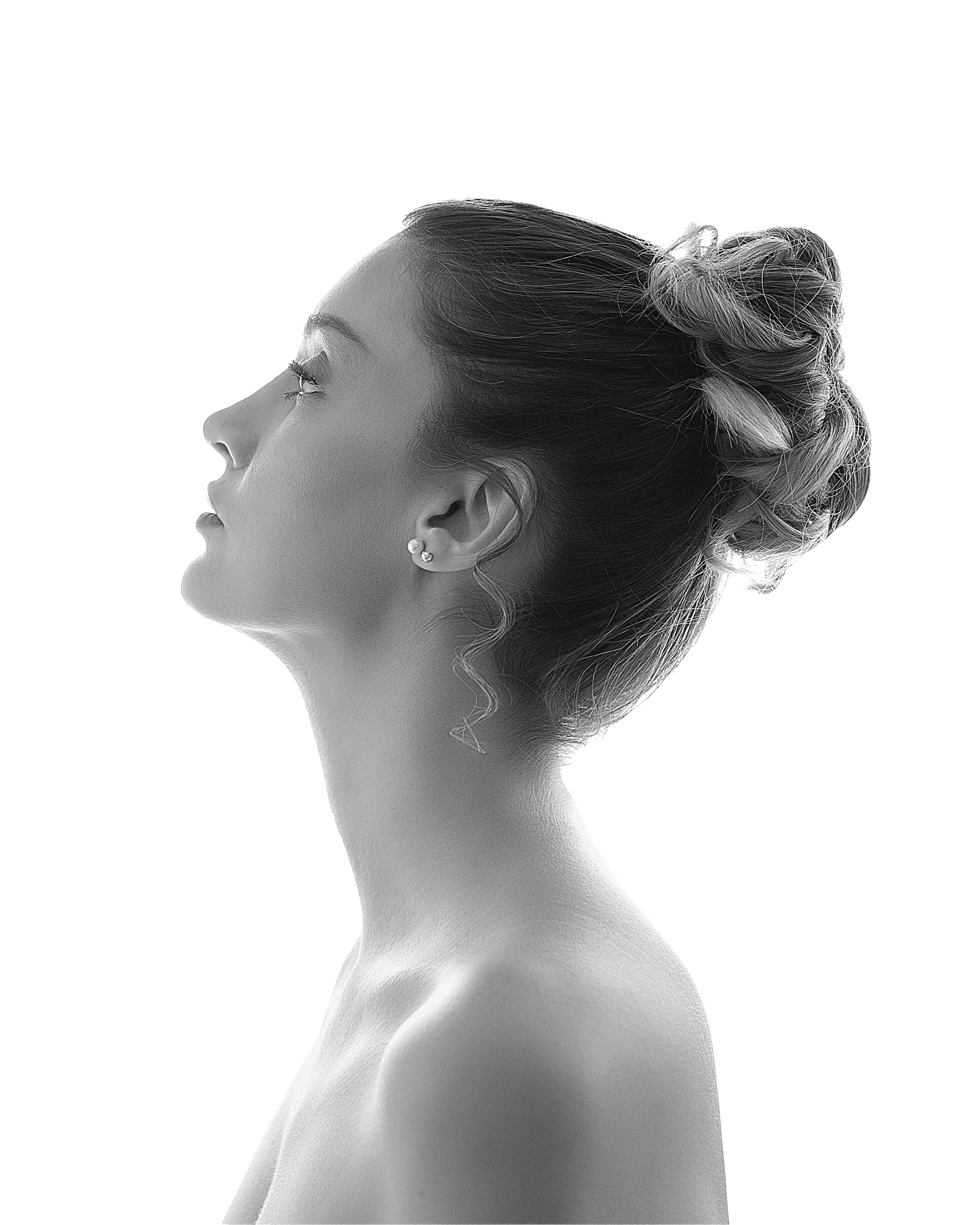 Retrato editorial en perfil, mirada dirigida hacia arriba, iluminación de estudio en blanco y negro